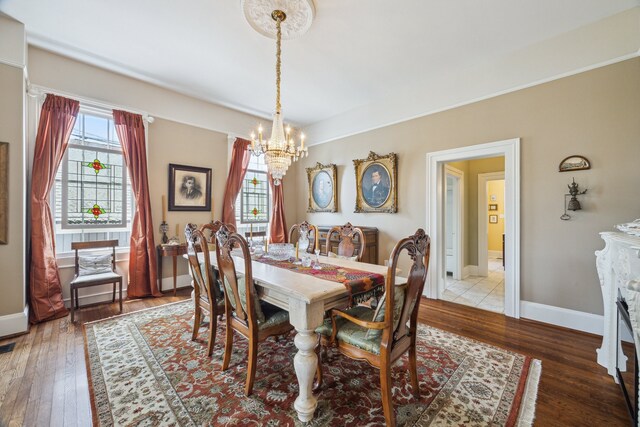 607 11th St, Galveston, TX 77550 - dining space with a chandelier, hardwood / wood-style flooring, and a fireplace