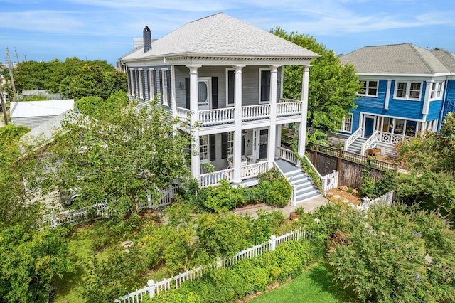 607 11th St, Galveston, TX 77550 - back of house with a balcony, covered porch, a fenced backyard, and a shingled roof