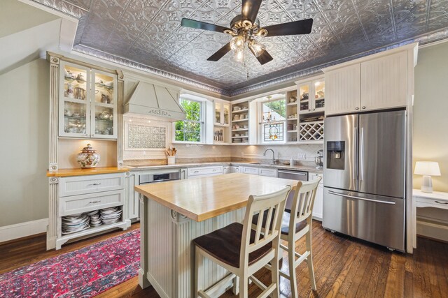 607 11th St, Galveston, TX 77550 - kitchen with appliances with stainless steel finishes, butcher block counters, an ornate ceiling, open shelves, and backsplash