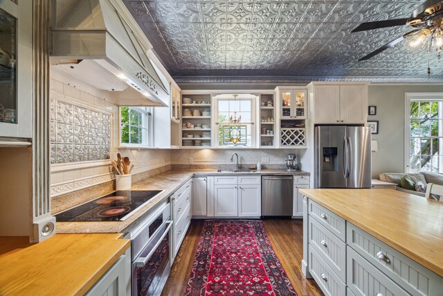 607 11th St, Galveston, TX 77550 - kitchen featuring appliances with stainless steel finishes, wood counters, open shelves, crown molding, and dark wood-style flooring