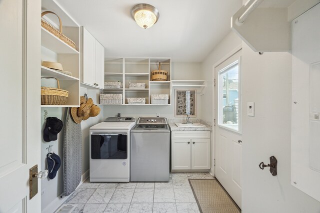 607 11th St, Galveston, TX 77550 - washroom with cabinet space, light marble finish floors, and washing machine and dryer