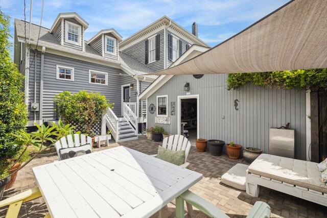 607 11th St, Galveston, TX 77550 - rear view of property featuring a patio area, outdoor dining area, and a shingled roof