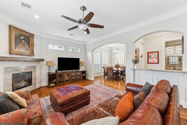 234 Knox St, Houston, TX 77007 - living room with arched walkways, wood finished floors, crown molding, a ceiling fan, and a chandelier