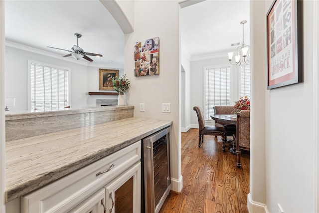 234 Knox St, Houston, TX 77007 - kitchen featuring wine cooler, crown molding, a chandelier, wood finished floors, and arched walkways