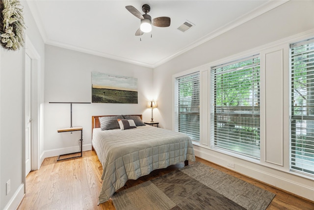 234 Knox St, Houston, TX 77007 - bedroom with light wood-type flooring, ornamental molding, and a ceiling fan