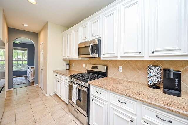 28503 Cece Glen Ct, Spring, TX 77386 - kitchen featuring appliances with stainless steel finishes, arched walkways, decorative backsplash, white cabinetry, and recessed lighting