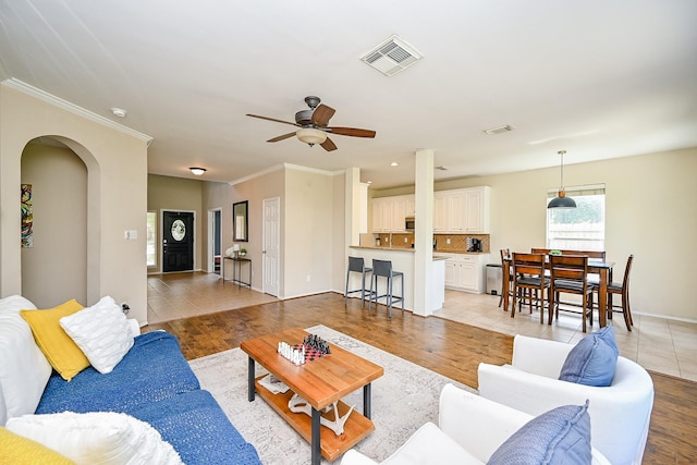 28503 Cece Glen Ct, Spring, TX 77386 - living area featuring arched walkways, crown molding, ceiling fan, and light wood-style floors