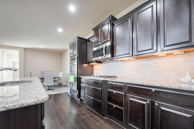 4310 Tilbury Trl, Richmond, TX 77407 - kitchen with stainless steel appliances, dark wood-type flooring, recessed lighting, light stone countertops, and backsplash