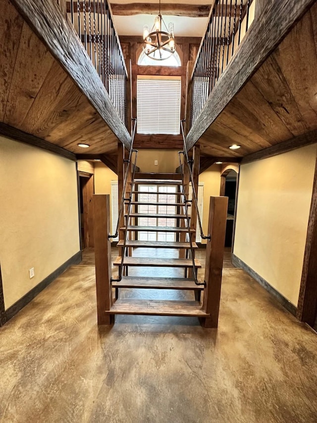 4842 Green Trail Dr, Houston, TX 77084 - stairs featuring arched walkways, concrete floors, wooden ceiling, and a chandelier