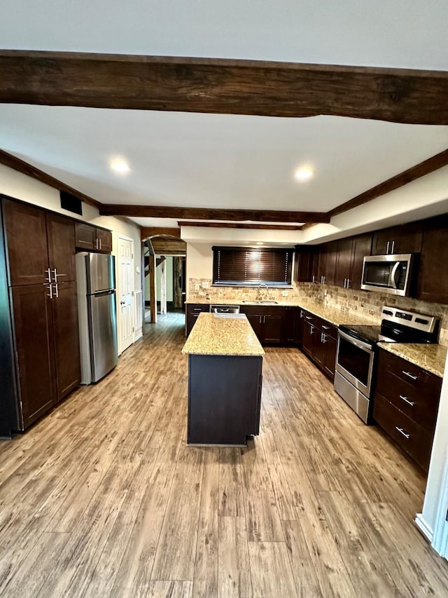 4842 Green Trail Dr, Houston, TX 77084 - kitchen with appliances with stainless steel finishes, light wood finished floors, decorative backsplash, dark brown cabinets, and recessed lighting