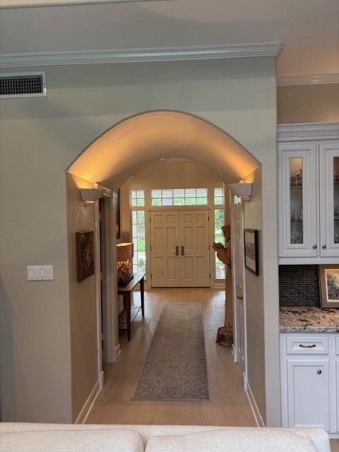 13718 Gainesway Dr, Cypress, TX 77429 - entrance foyer with arched walkways, ornamental molding, and light wood-type flooring