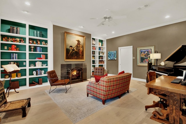 13718 Gainesway Dr, Cypress, TX 77429 - office space featuring ceiling fan, built in shelves, a fireplace with flush hearth, crown molding, and wood finished floors