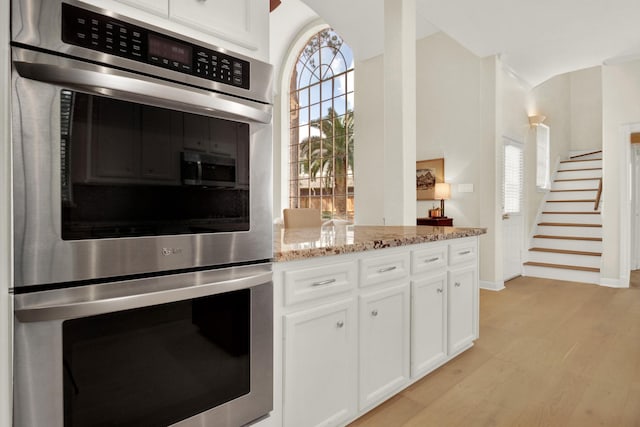 13718 Gainesway Dr, Cypress, TX 77429 - kitchen with double oven, white cabinets, light stone countertops, and light wood-type flooring