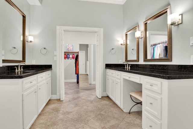 13718 Gainesway Dr, Cypress, TX 77429 - bathroom with two vanities, a spacious closet, tile patterned flooring, and crown molding