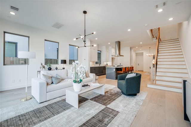 1937 W Clay St, Houston, TX 77019 - living room featuring a chandelier, light wood finished floors, stairway, and recessed lighting