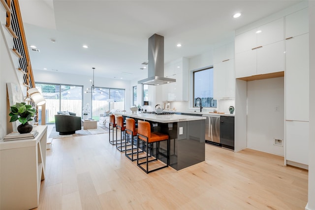 1937 W Clay St, Houston, TX 77019 - kitchen featuring island range hood, modern cabinets, dishwasher, light wood-style floors, and a kitchen breakfast bar