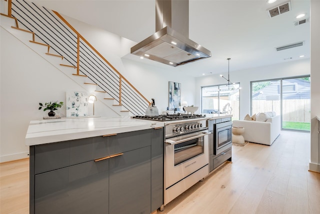 1937 W Clay St, Houston, TX 77019 - kitchen with exhaust hood, gray cabinetry, high end range, modern cabinets, and light wood-type flooring