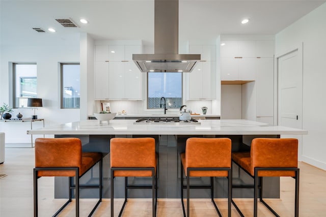1937 W Clay St, Houston, TX 77019 - kitchen featuring island exhaust hood, modern cabinets, white cabinetry, stainless steel gas cooktop, and recessed lighting