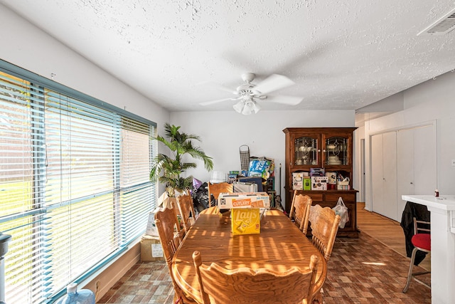 3822 Quiet Place Dr, Houston, TX 77082 - dining space with ceiling fan, a textured ceiling, and brick patterned floors