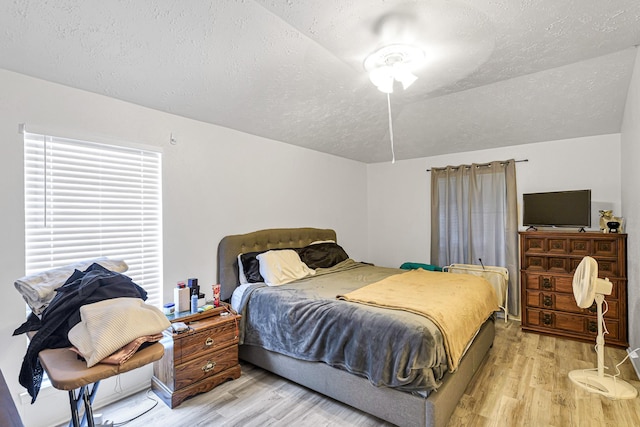 3822 Quiet Place Dr, Houston, TX 77082 - bedroom featuring a textured ceiling, light wood-type flooring, and vaulted ceiling
