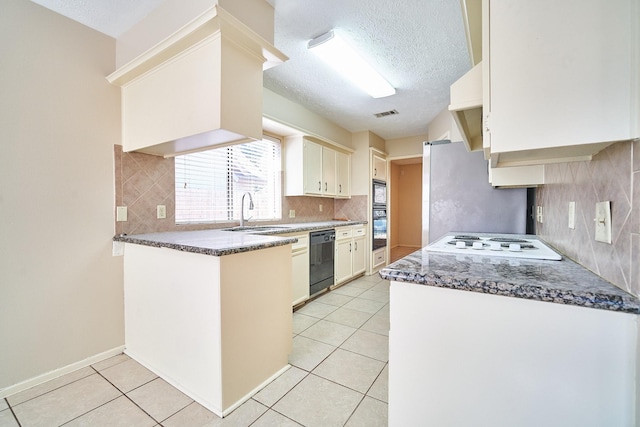 14835 Delbarton Dr, Houston, TX 77083 - kitchen with black dishwasher, a textured ceiling, freestanding refrigerator, light tile patterned floors, and backsplash