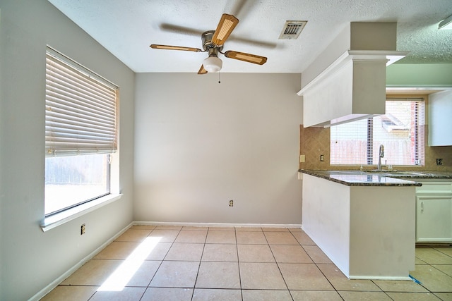 14835 Delbarton Dr, Houston, TX 77083 - kitchen with decorative backsplash, ceiling fan, plenty of natural light, light tile patterned flooring, and a textured ceiling