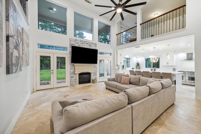 14610 Majestic Oaks, Magnolia, TX 77354 - living area with a towering ceiling, ceiling fan, french doors, and a stone fireplace