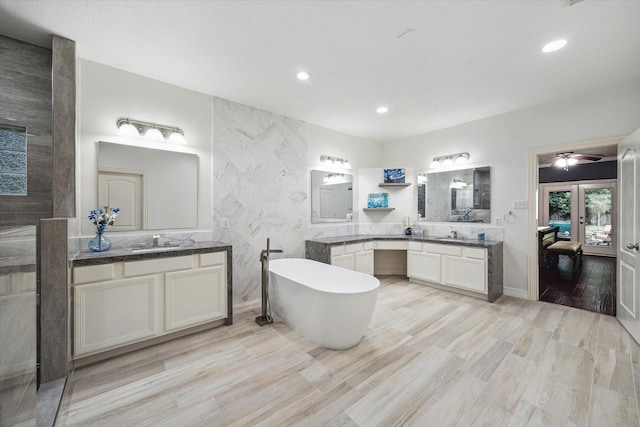 14610 Majestic Oaks, Magnolia, TX 77354 - full bath featuring a soaking tub, two vanities, recessed lighting, wood finished floors, and french doors