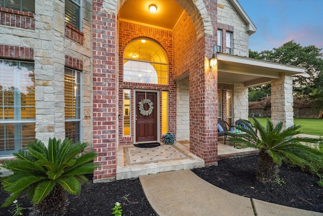 14610 Majestic Oaks, Magnolia, TX 77354 - exterior entry at dusk featuring a porch and brick siding