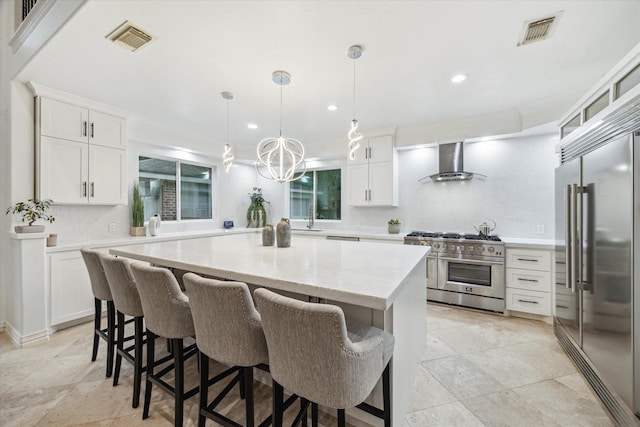 14610 Majestic Oaks, Magnolia, TX 77354 - kitchen with wall chimney exhaust hood, high quality appliances, decorative backsplash, a kitchen island, and a kitchen bar