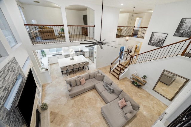 14610 Majestic Oaks, Magnolia, TX 77354 - living area with a high ceiling, arched walkways, ceiling fan, and stairway