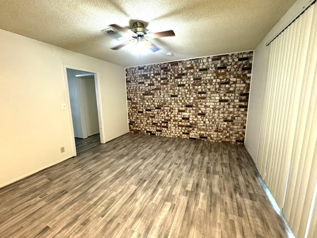 1722 Briar Ln, Wharton, TX 77488 - empty room featuring wood finished floors, a ceiling fan, brick wall, and a textured ceiling