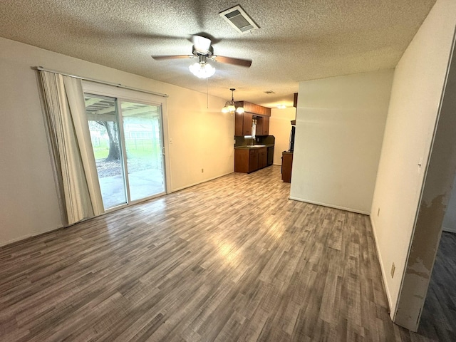 1722 Briar Ln, Wharton, TX 77488 - unfurnished living room with dark wood-style flooring, a ceiling fan, and a textured ceiling