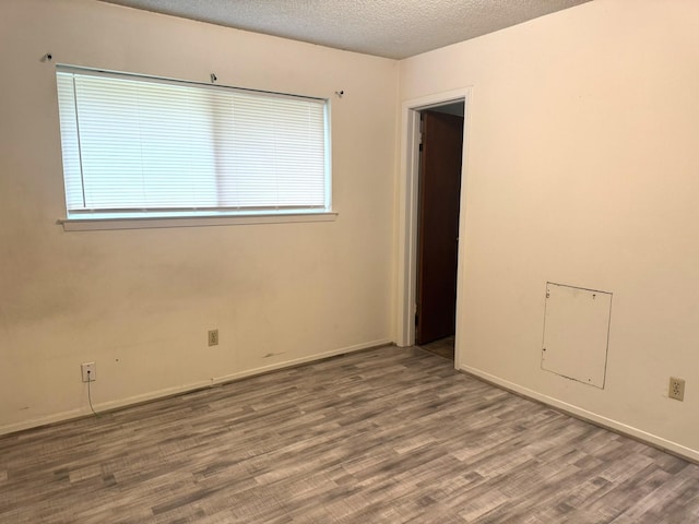 1722 Briar Ln, Wharton, TX 77488 - spare room featuring wood finished floors, a textured ceiling, and plenty of natural light