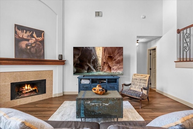 6907 Autumn Rain Ln, Spring, TX 77379 - living area featuring wood finished floors, a tile fireplace, and a high ceiling