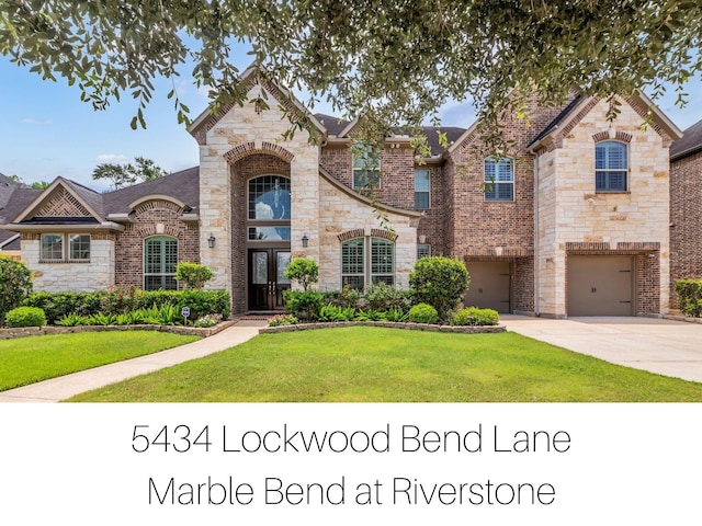 5434 Lockwood Bend Ln, Sugar Land, TX 77479 - french country style house featuring concrete driveway, a front yard, stone siding, and a garage