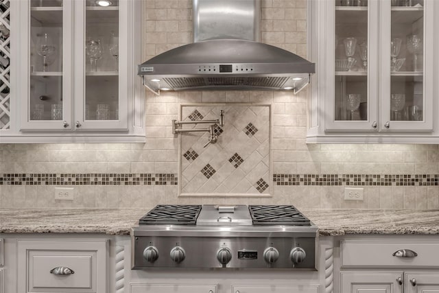 5434 Lockwood Bend Ln, Sugar Land, TX 77479 - kitchen with wall chimney exhaust hood, stainless steel gas stovetop, backsplash, and white cabinetry