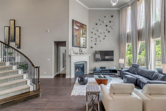 5434 Lockwood Bend Ln, Sugar Land, TX 77479 - living room with a high ceiling, stairs, dark wood finished floors, crown molding, and a glass covered fireplace