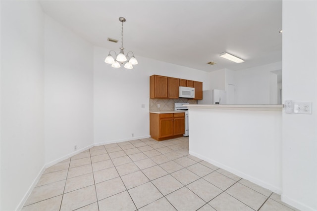 20126 Cypresswood Gln, Spring, TX 77373 - kitchen featuring white appliances, light countertops, brown cabinets, decorative backsplash, and a chandelier