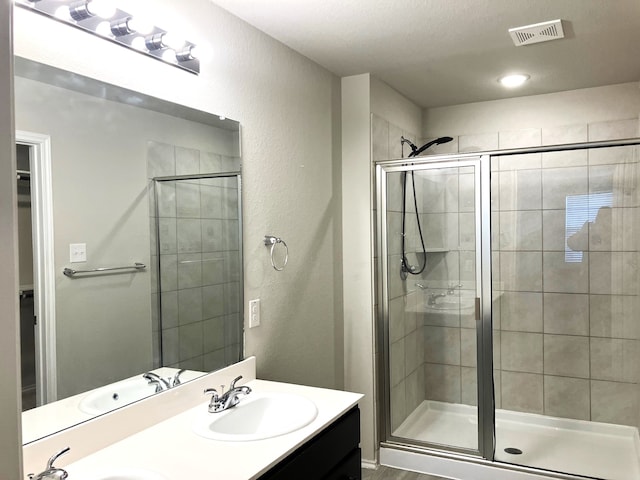 15806 Perthshire Creek Dr, Humble, TX 77346 - full bathroom featuring a stall shower, double vanity, and a textured wall