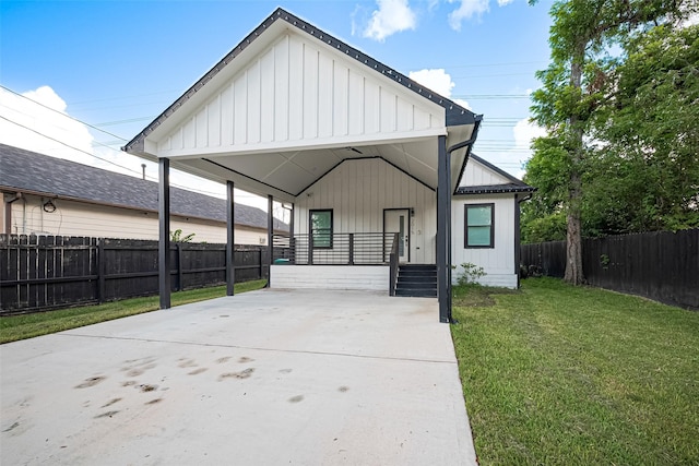 2015 Creston Dr, Houston, TX 77026 - view of front of home with concrete driveway, a carport, board and batten siding, and covered porch