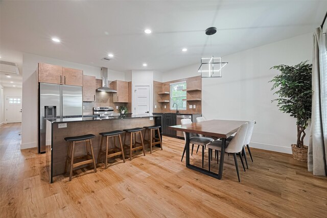 2015 Creston Dr, Houston, TX 77026 - kitchen with wall chimney exhaust hood, stainless steel appliances, dark countertops, open shelves, and a center island