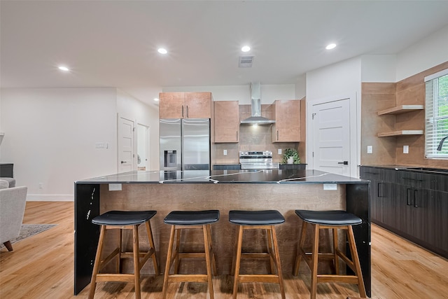 2015 Creston Dr, Houston, TX 77026 - kitchen with stainless steel appliances, wall chimney range hood, decorative backsplash, a breakfast bar, and recessed lighting