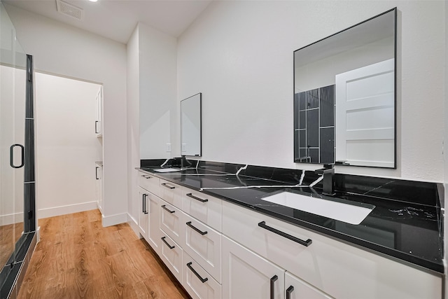 2015 Creston Dr, Houston, TX 77026 - full bath featuring double vanity, wood finished floors, and a stall shower