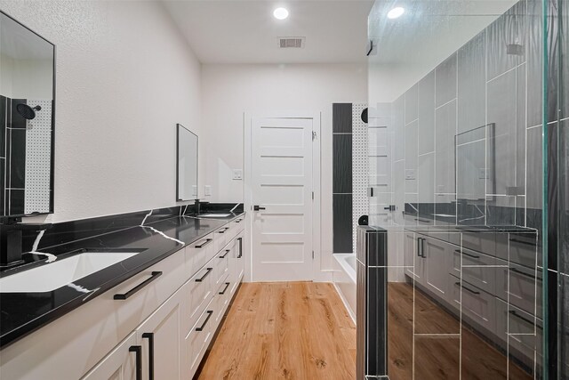 2015 Creston Dr, Houston, TX 77026 - full bathroom featuring double vanity, wood finished floors, tub / shower combination, and recessed lighting