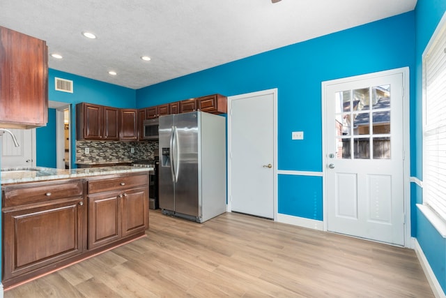 5602 Society Ln, Houston, TX 77084 - kitchen with appliances with stainless steel finishes, light wood finished floors, tasteful backsplash, recessed lighting, and healthy amount of natural light