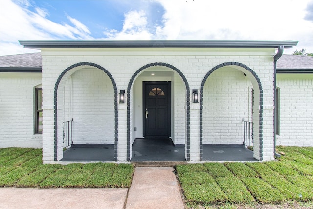 11523 Bandlon Dr, Houston, TX 77072 - view of exterior entry with brick siding, roof with shingles, and covered porch