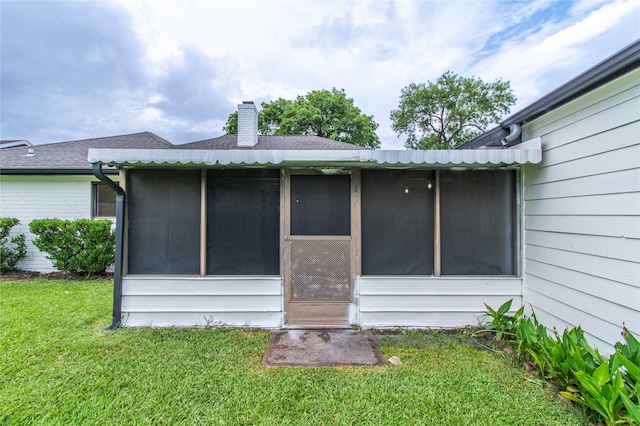 11523 Bandlon Dr, Houston, TX 77072 - rear view of house featuring a chimney, a yard, a sunroom, roof with shingles, and brick siding