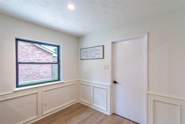 11523 Bandlon Dr, Houston, TX 77072 - unfurnished room featuring light wood-style floors, wainscoting, and a decorative wall