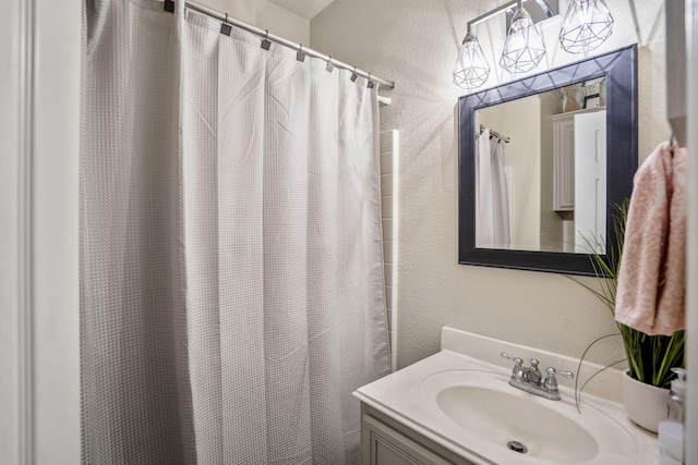 18605 Syndee Loch Ct, Spring, TX 77379 - bathroom featuring vanity, a textured wall, and a shower with curtain